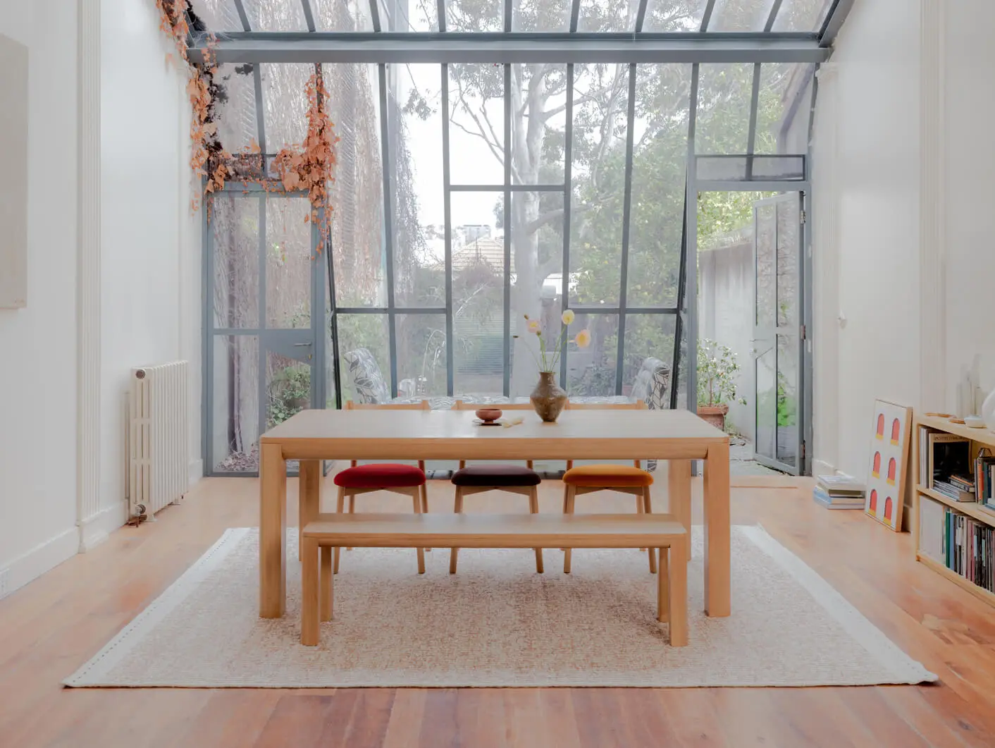 Interior dining area in modern house with glass windows and an american oak Alor dining set with Charlie dining chairs and Bowie bench seat.